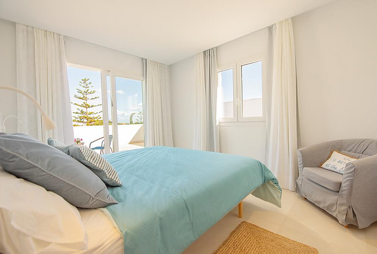 Schlafzimmer mit Doppelbett und Terrassentür