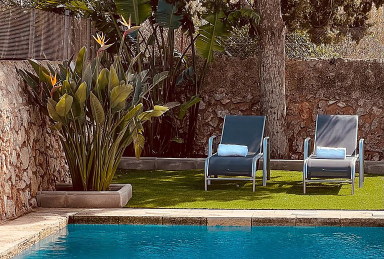 Pool mit Sonnenliegen im Schatten
