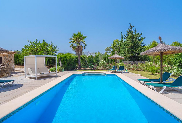Pool mit Sonnenliegen und Sonnenschirm