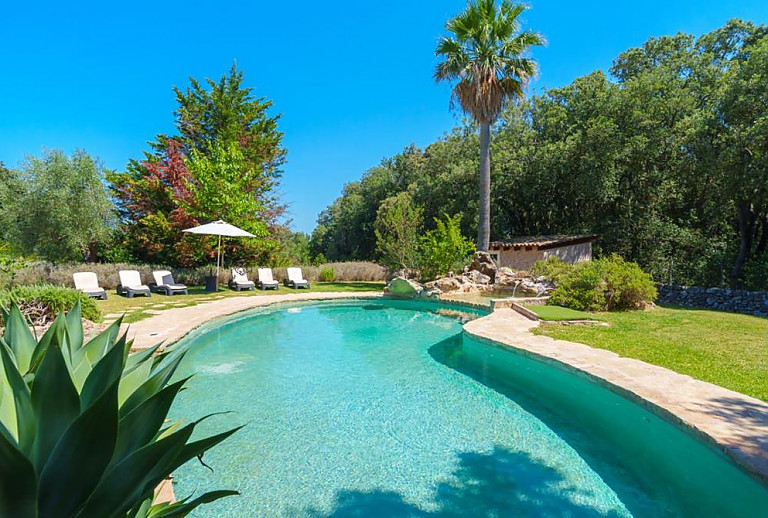 Sonnenschirm und Poolliegen am Pool