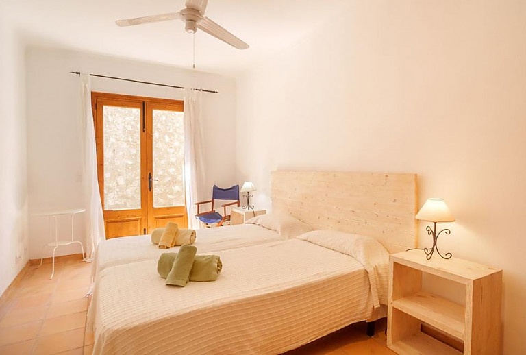 Schlafzimmer mit Einzelbetten und Zugang nach draußen