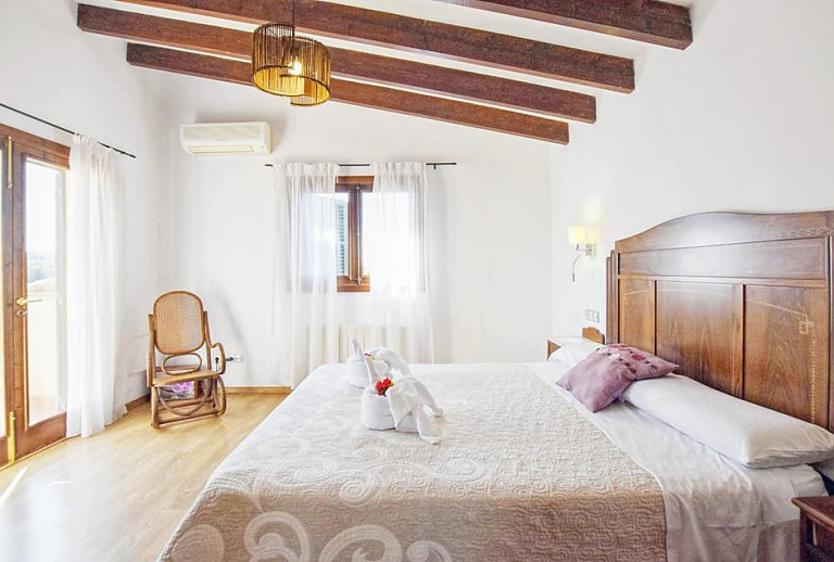 Schlafzimmer mit Doppelbett und Schaukelstuhl