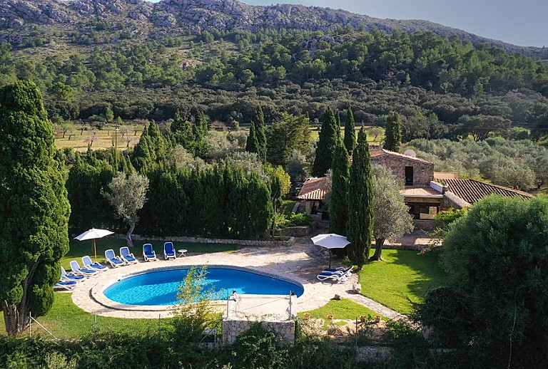 Pool mit Sonnenliegen und Rasen vor der Finca