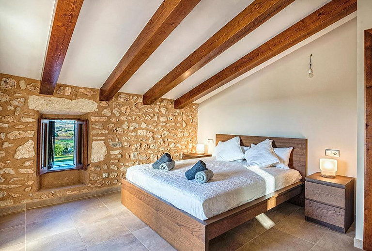 Natursteinwände im Schlafzimmer mit Doppelbett 