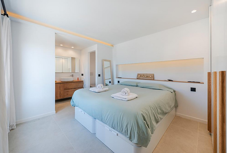 Schlafzimmer mit Doppelbett und Badezimmer