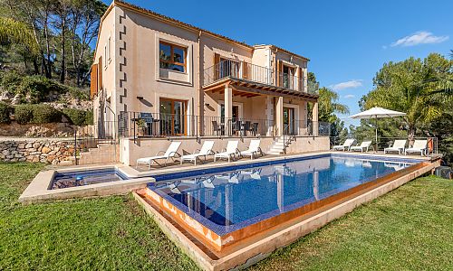 Pool mit Sonnenschirm und Poolliegen vor der Finca