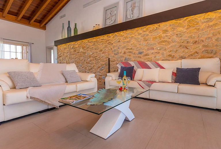Wohnzimmer mit Natursteinwand und Couch