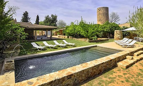 Rasen und Sonnenliegen am Pool vor der Finca