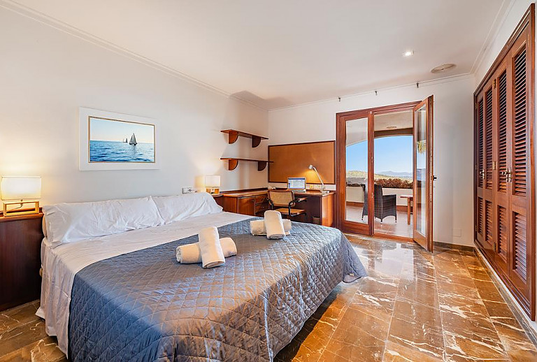 Schlafzimmer mit Doppelbett und Schreibtisch