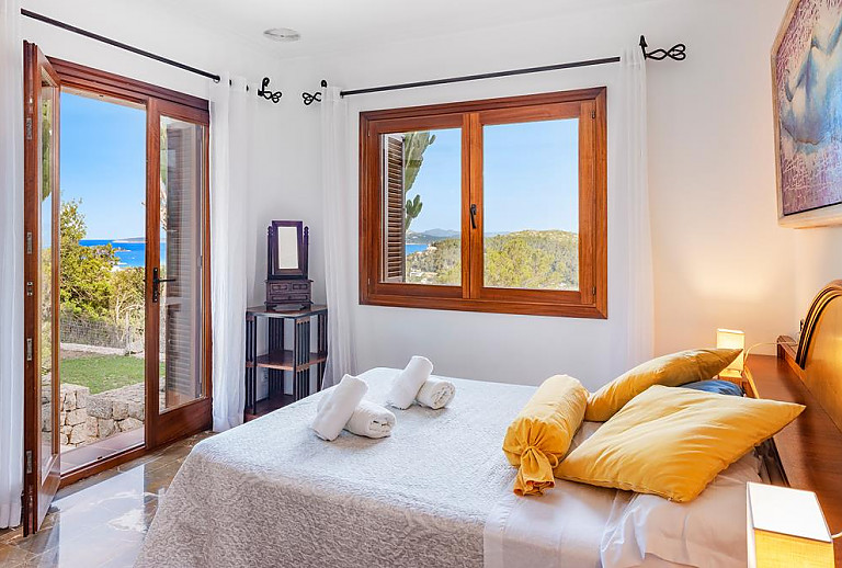 Schlafzimmer mit Doppelbett und Zugang zum Garten