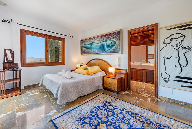 Schlafzimmer mit Doppelbett und Badezimmer