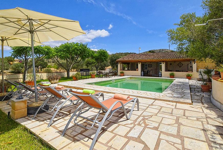 Pool mit Liegen und Sonnenschirm vor der Finca