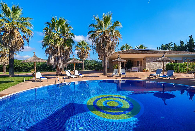 Pool mit Sonnenliegen und Sonnenschirm vor der Finca