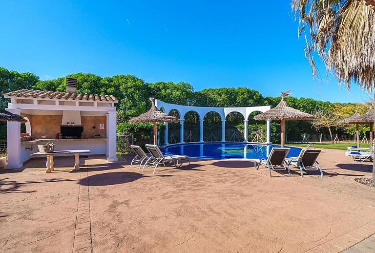 Pool mit Sonnenliegen und Sonnenschirm vor der Finca