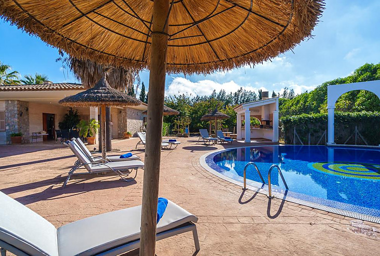 Sonnenliegen und Sonnenschirm am Pool