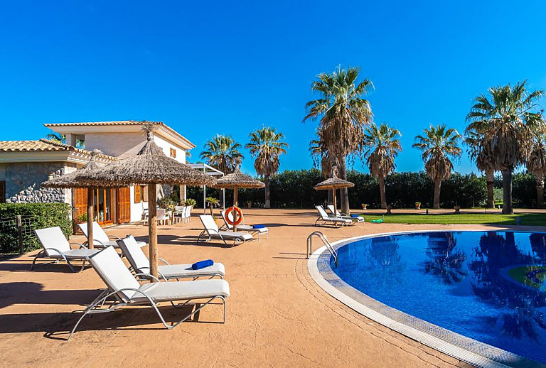 Liegen und Sonnenschirmen vor der Finca