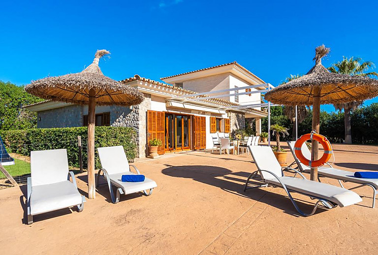Poolliegen und Sonnenschirmen vor der Finca