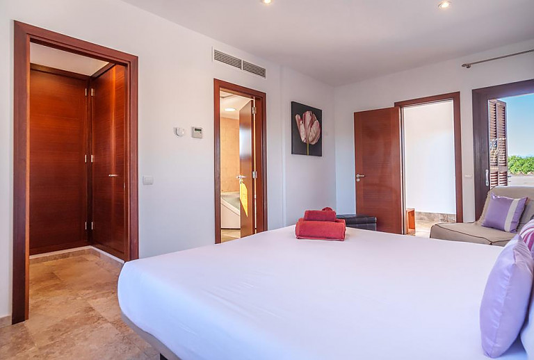 Schlafzimmer mit Doppelbett und Badezimmer
