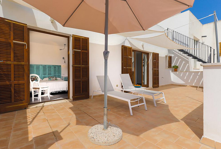 Sonnenschirm und Poolliegen auf der Terrasse
