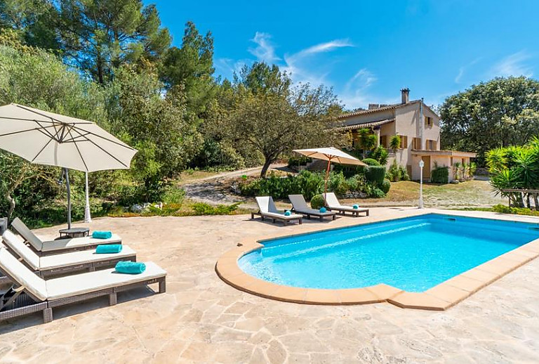 Poolbereich mit Sonnenliegen vor der Finca