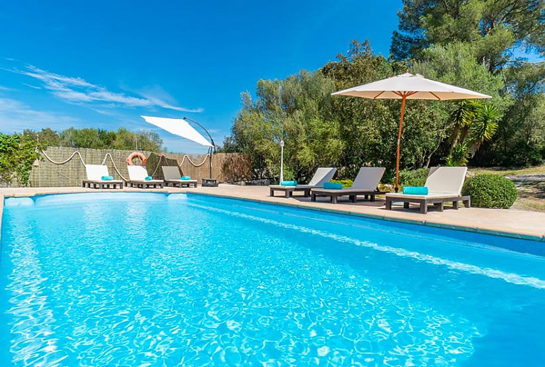 Pool mit Sonnenschirm und Poolliegen