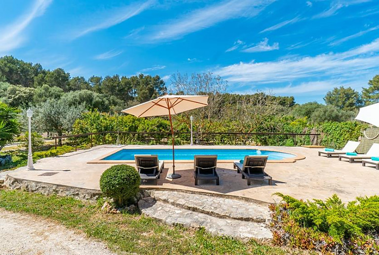 Poolbereich mit Liegen und Sonnenschirm