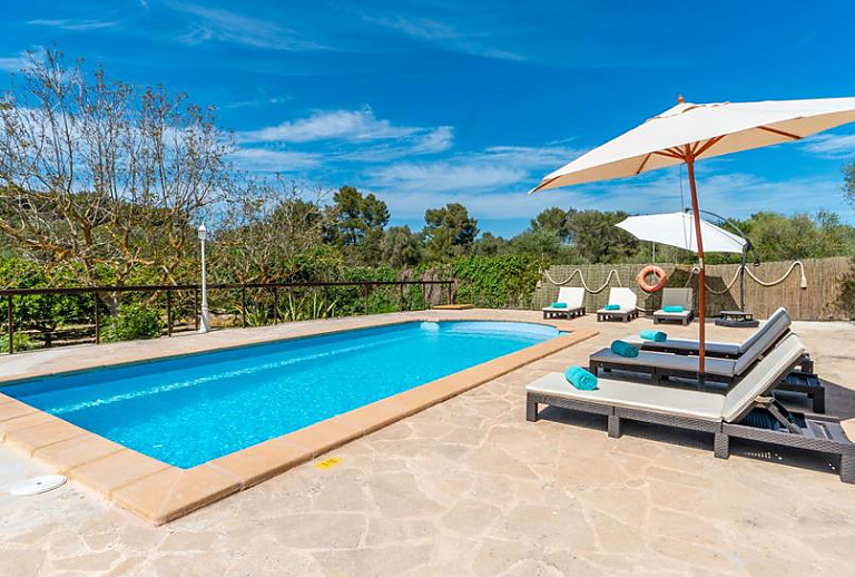 Poolbereich mit Liegen und Sonnenschirm