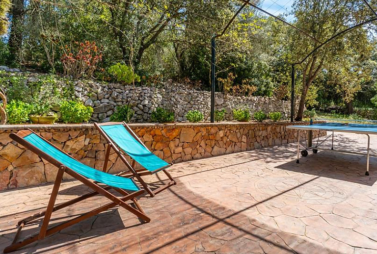 Tischtennisplatte im Garten mit Sonnenstühlen