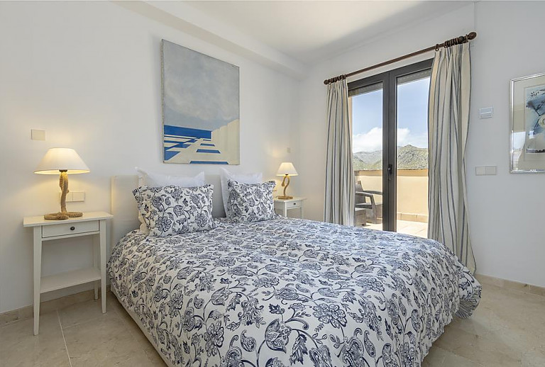 Schlafzimmer mit Doppelbett und Balkonzugang