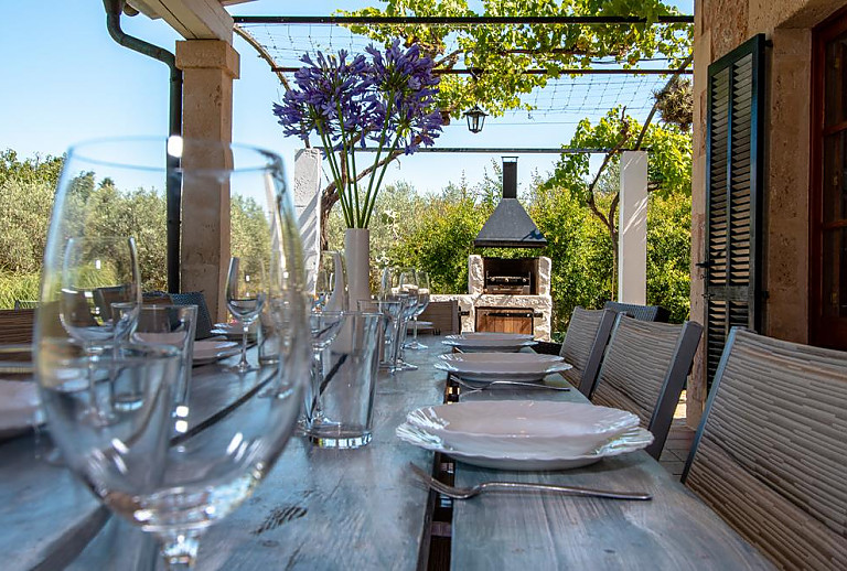 Terrasse mit Vordach und Esstisch mit Geschirr