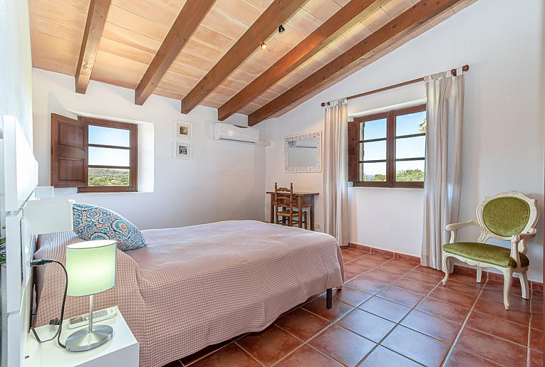 Schlafzimmer mit Doppelbett und Schreibtisch