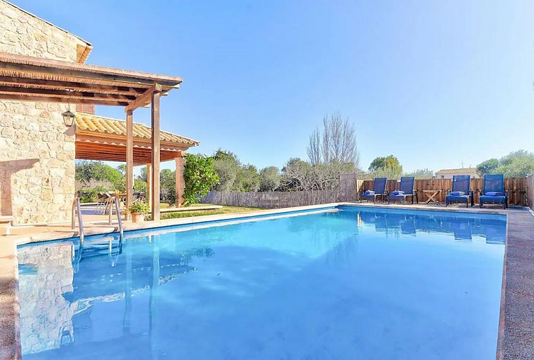 Pool mit Sonnenliegen vor der Finca