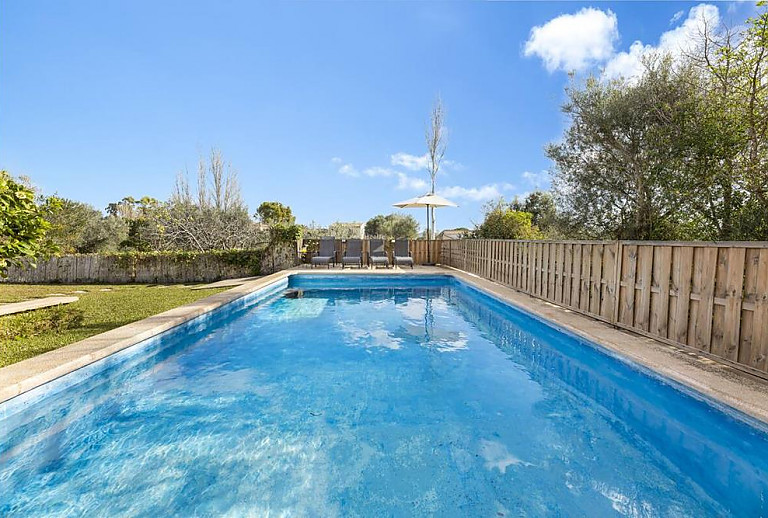 Sonnenschirm und Sonnenliegen am Pool