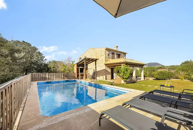 Außenbereich mit Pool und Sonnenliegen