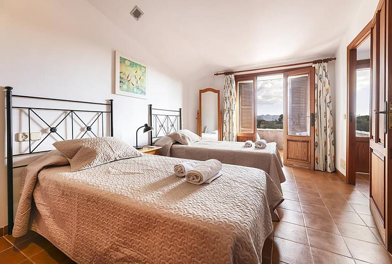 Schlafzimmer mit Einzelbetten und Balkon