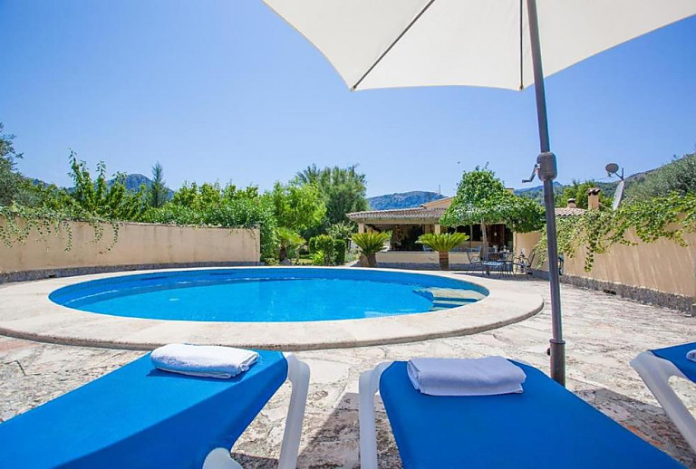 Pool im Garten mit Sonnenliegen und Sonnenschirm