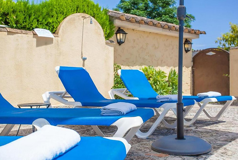 Garten mit Poolliegen im Schatten