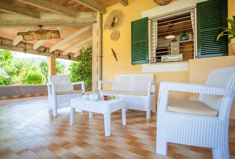 Terrasse mit Vordach und Sitzmöbeln