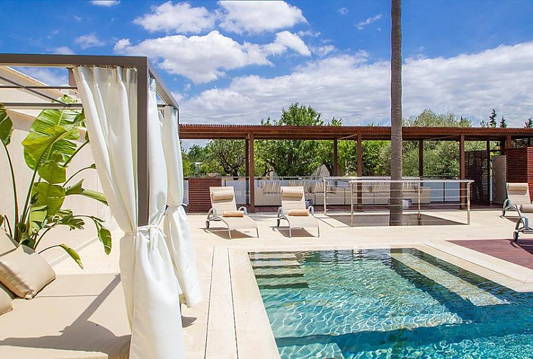 Poolbereich mit Sonnenliegen und Loungemöbel