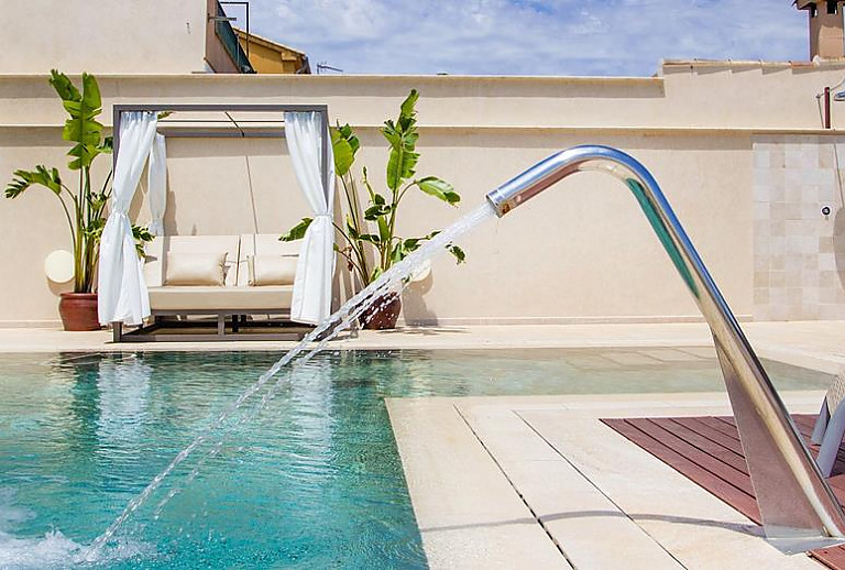 Daybed mit Topfpflanzen am Pool