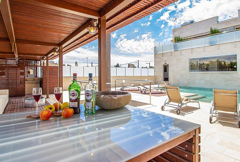 Esstisch auf der überdachten Terrasse am Pool