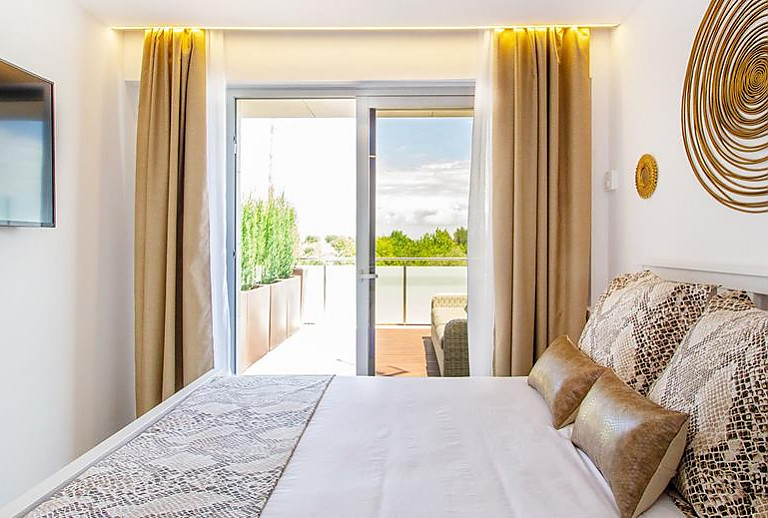 Schlafzimmer mit Doppelbett und Fernseher
