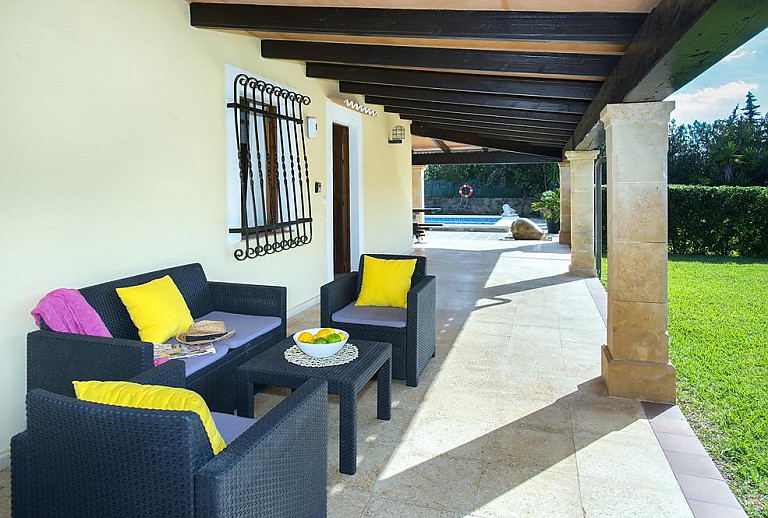 Terrasse mit Vordach und Sitzmöbeln