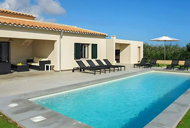 Liegestühle am Pool vor der Finca