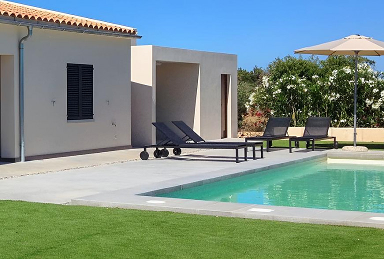 Rasen am Pool mit Poolliegen