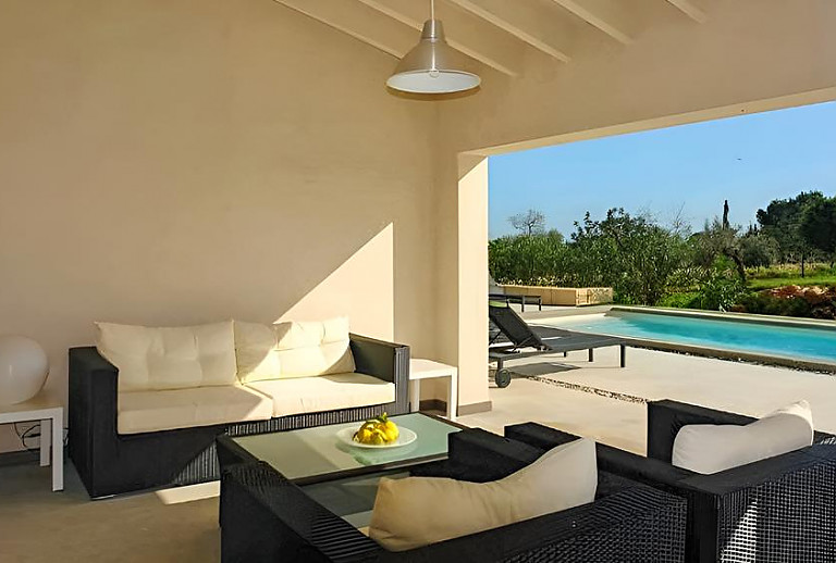 Terrasse mit Vordach und Gartenmöbeln
