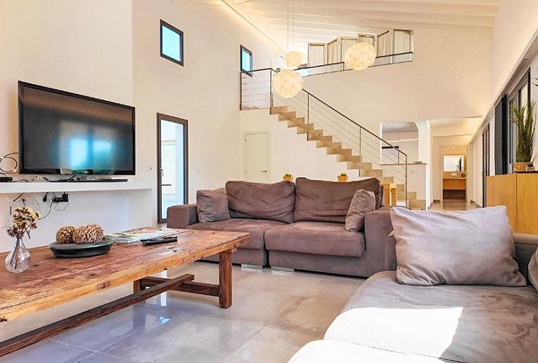 Wohnzimmer mit Fernseher und Sofas