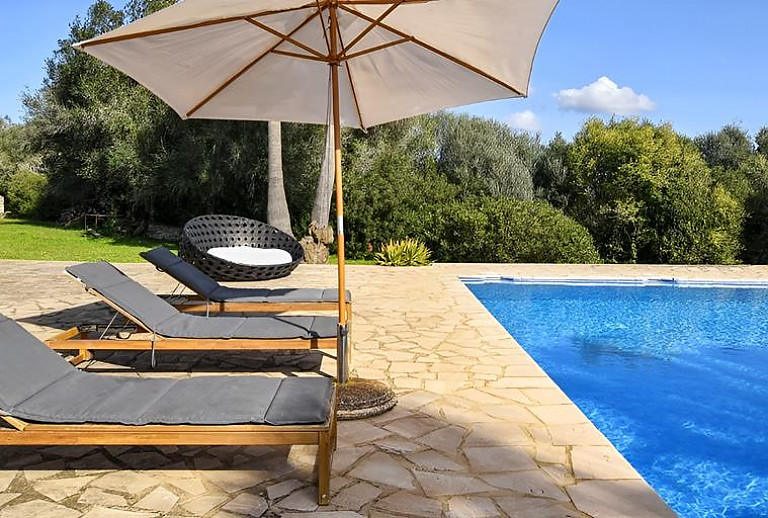 Poolliegen und Sonnenschirm am Pool