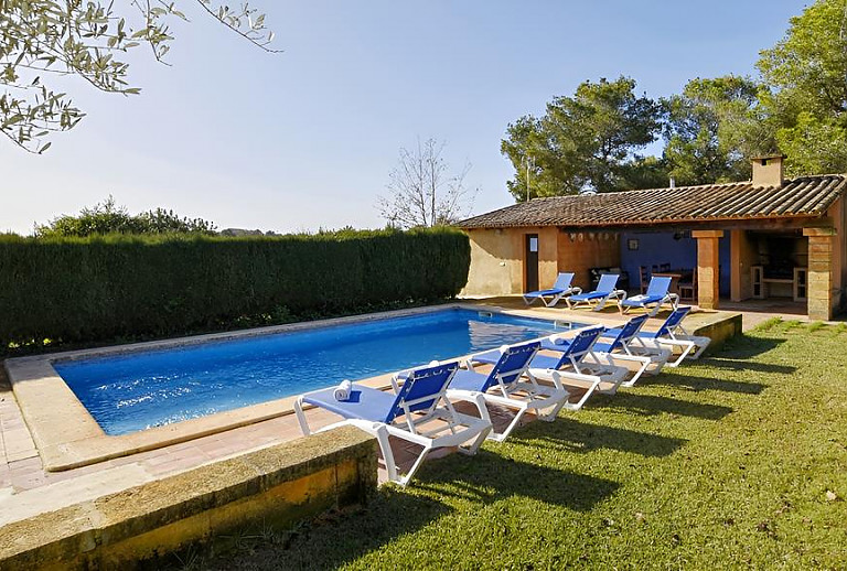 Rasen und Sonnenliegen am Pool