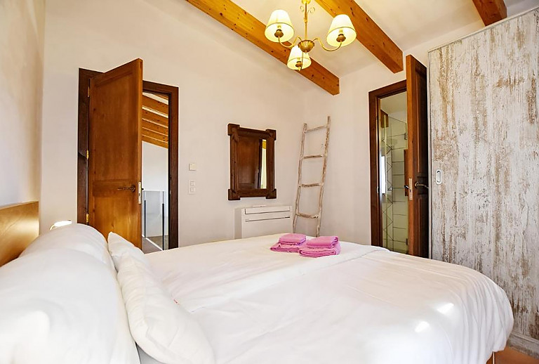 Schlafzimmer mit Doppelbett und Badezimmer